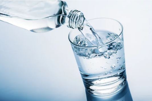 eau servis dans un verre par une bouteille